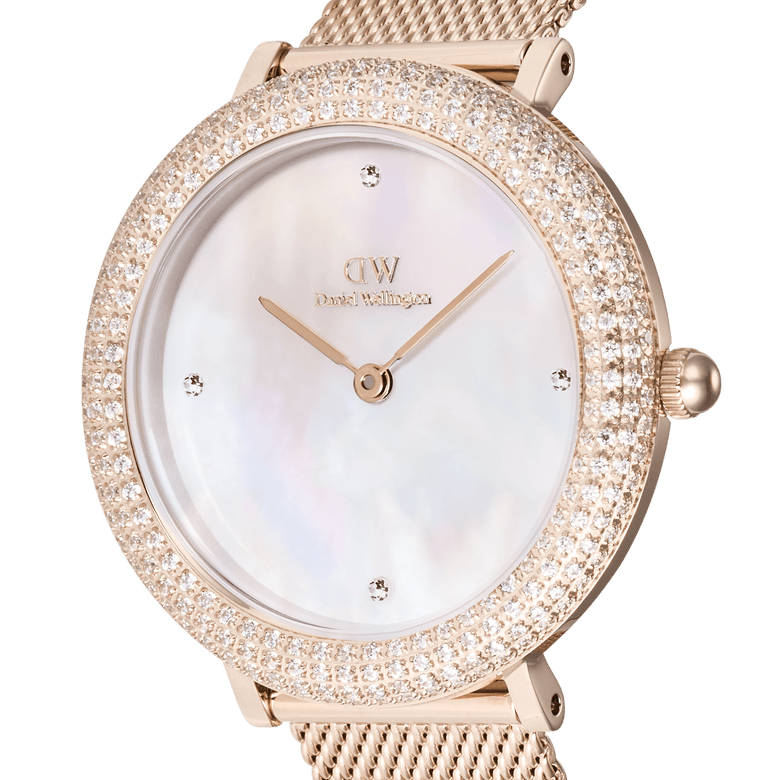 Close-up of the Crystalline Bezel Melrose rose gold ladies watch, highlighting its double row of sparkling crystals around the bezel, white mother of pearl dial with four crystal markers, and elegant rose gold mesh strap.