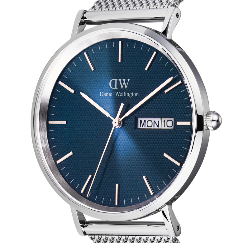 Close-up of the Classic Day Display Sterling Arctic watch showing the blue dial with a semi-transparent triangle pattern, silver hour markers, and a day and date window.
