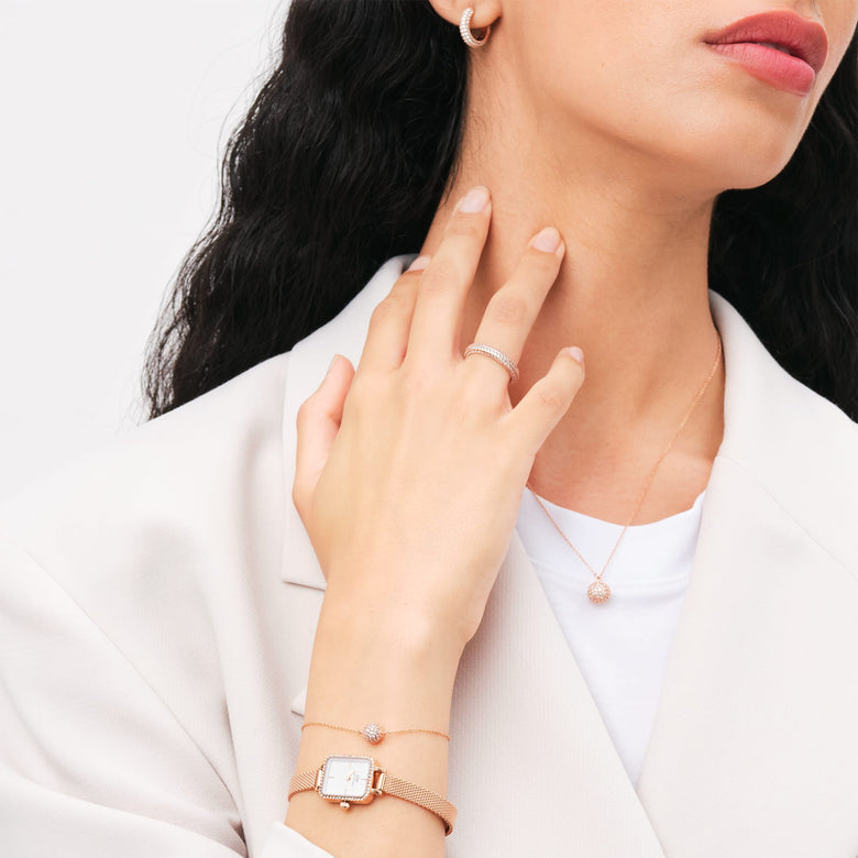 A woman wearing the Pavé Crystal Ring Rose Gold, styled with matching rose gold jewellery including a necklace, earrings, and watch, highlighting the ring’s sparkling cubic zirconia crystals and elegant design for everyday wear.