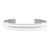 Emalie Bracelet Silver showcases a sleek open cuff style with polished silver and satin white enamel detailing, featuring the Daniel Wellington branding engraved across the front.