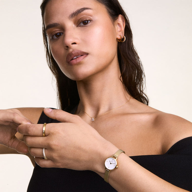 Woman wearing the Petite Mini & Pave Crystal Ring Gold Set, featuring a petite gold mesh strap watch with a white dial and a pavé crystal ring, styled with a black top for a modern, elegant look.