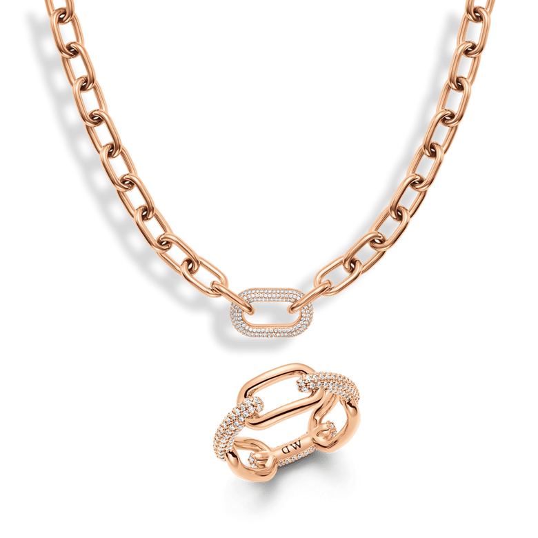 Rose gold chain necklace and matching crystal link ring featuring pavé stones, both showcasing a bold link motif with a modern, elegant finish.