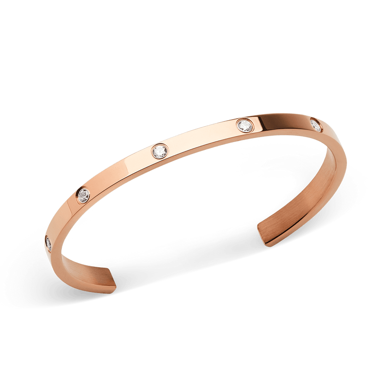 Classic Lumine Bracelet Rose Gold 55mm shown at an angle, highlighting its polished rose gold finish and eight sparkling cubic zirconia crystals set along the slim, open cuff design.