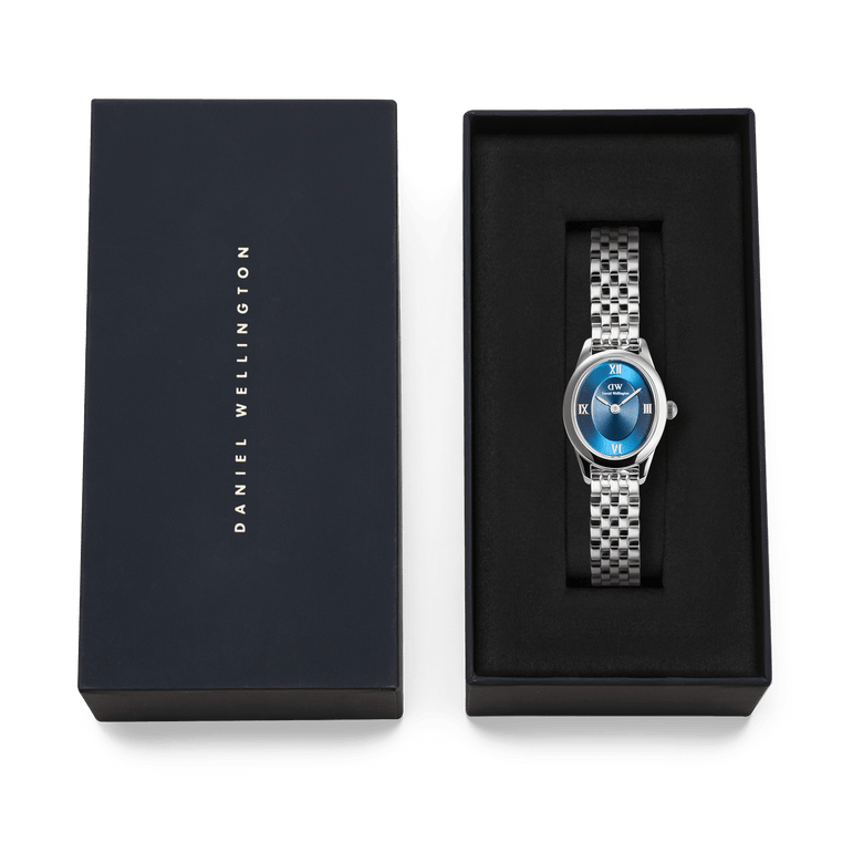 Ophelia Mini Arctic Silver ladies watch with a polished silver oval case, blue sunray dial, and slim 5-link bracelet, presented in a Daniel Wellington branded gift box.