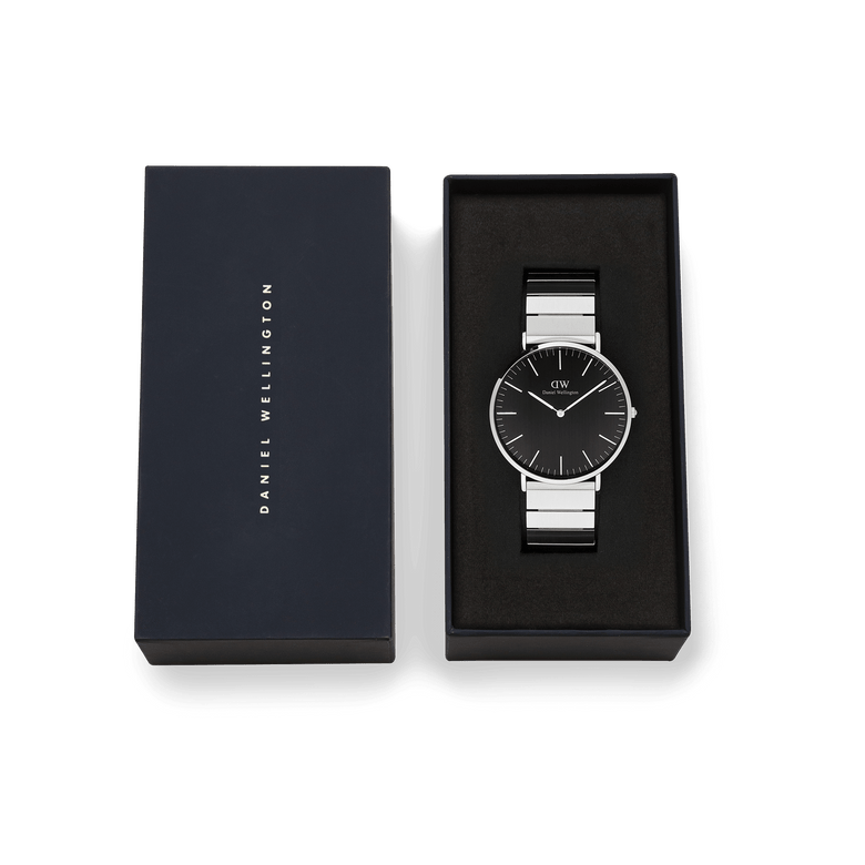 Classic Piano Link Onyx Silver men’s watch with a brushed black dial and geometric silver piano link strap, presented in a branded Daniel Wellington gift box.