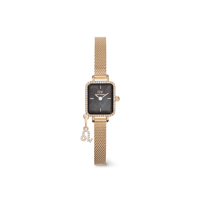 Elegant Daniel Wellington Quadro Mini Crystal Zodiac Evergold Set featuring a rectangular gold case with crystal detailing, a black mother of pearl dial, and an adjustable gold mesh strap with a crystal zodiac charm.