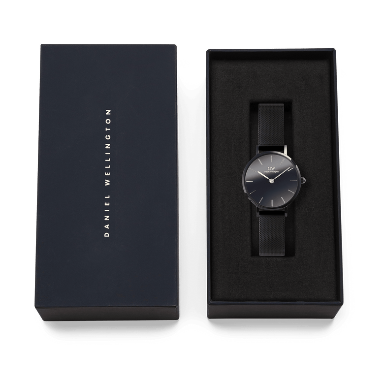 Daniel Wellington Petite Reflection Black watch with a black mesh strap and minimalist black dial, elegantly presented in a branded gift box.