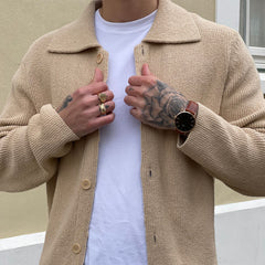 Classic St Mawes Amber Rose Gold men’s watch with a sunray brown dial and brown Italian Nappa leather strap, worn with a beige textured cardigan and white T-shirt for a smart casual look.