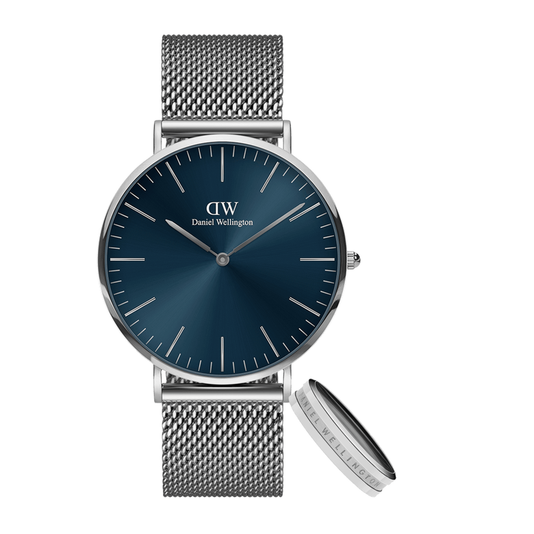 Silver mesh strap watch with a blue dial and matching silver Elan Ring S, both featuring minimalist styling and Daniel Wellington branding, ideal for gifting or everyday wear.