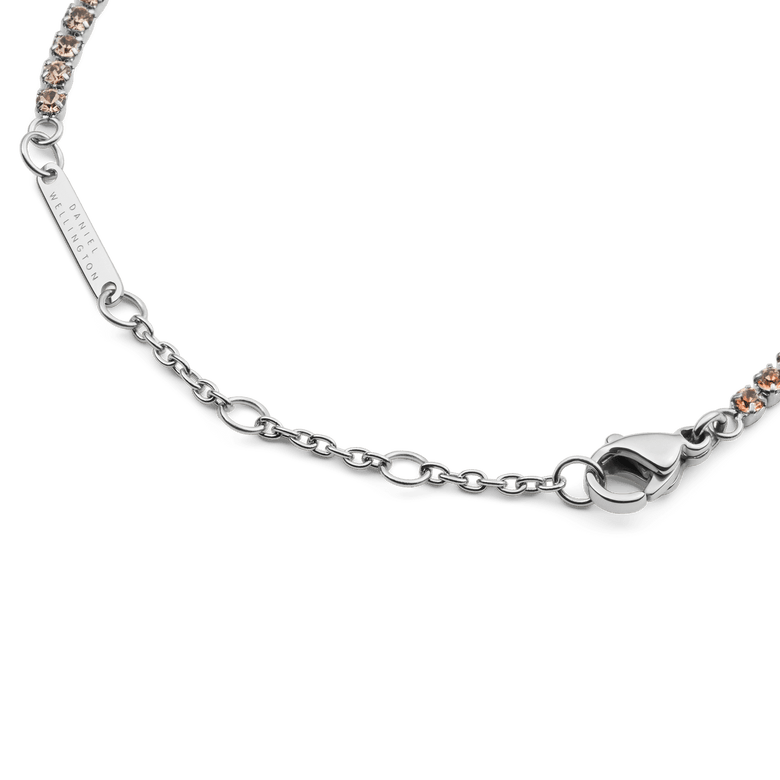 Detail of the Classic Tennis Bracelet Apricot Silver showing the adjustable sizing rings, lobster clasp, and individually set apricot-coloured crystals on a sleek silver chain.