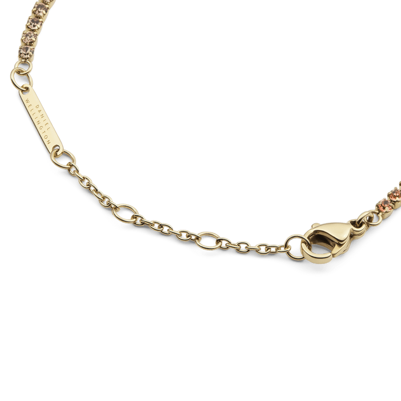 Detail of the Classic Tennis Bracelet Apricot Gold showing the gold lobster clasp, adjustable sizing rings, and individually set apricot-coloured crystals.