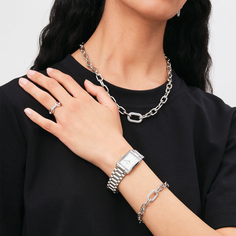 Bound 3-Link Silver watch styled on a wrist with matching silver jewellery, showcasing its rectangular case, three-link bracelet, and minimalist white dial for a modern everyday look.
