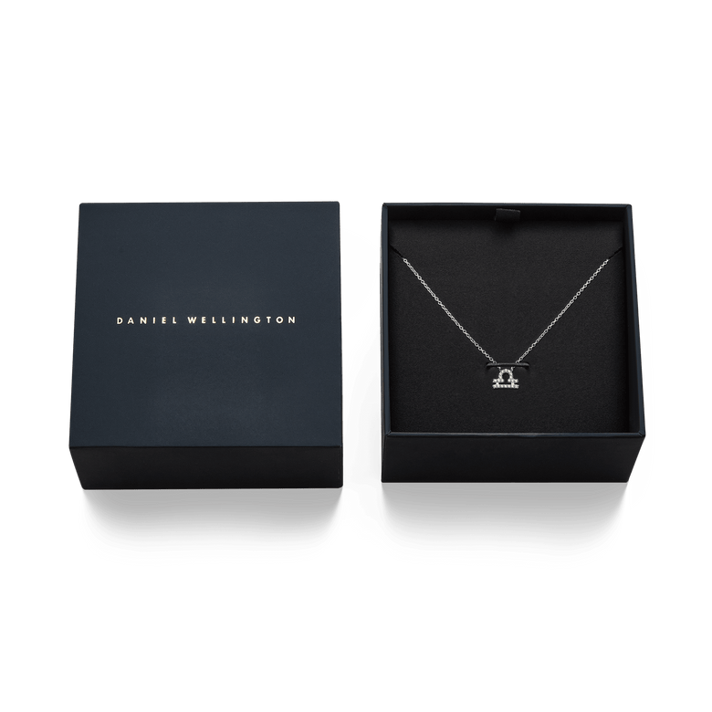 Crystal Zodiac Chain Necklace Silver with a Libra zodiac pendant set with hand-set crystals, elegantly presented in an open designer gift box next to a closed box with Daniel Wellington branding.