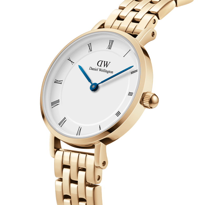 Close-up of the Petite Roman Numerals 5-Link Gold watch showing its polished gold bracelet, minimalist white dial with Roman numerals, and striking blue steel hands.