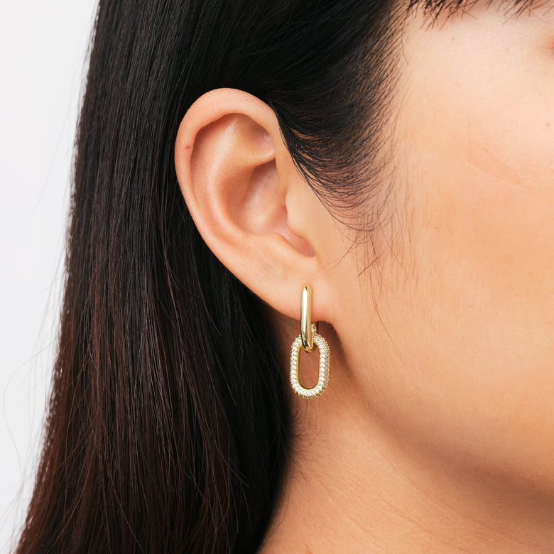 Crystal Link Earrings Gold worn on the ear, showcasing the gold plated brass link design with sparkling cubic zirconia crystals, perfect for adding a touch of elegance to everyday style.