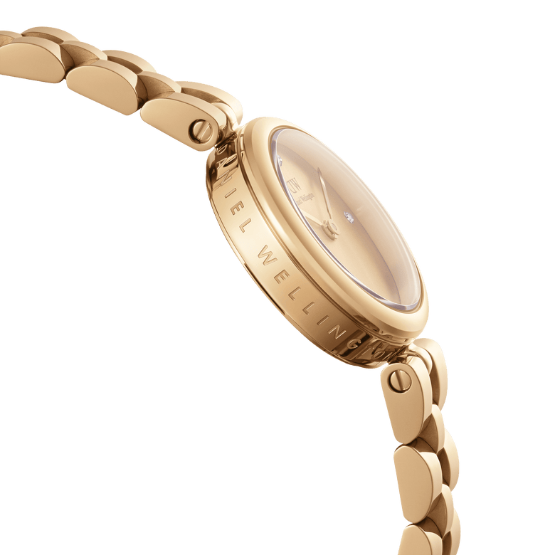 Close-up side view of the Elan Lumine Unitone Gold ladies watch, highlighting the engraved Daniel Wellington branding on the gold case, the crystal dial, and the polished three-link bracelet.