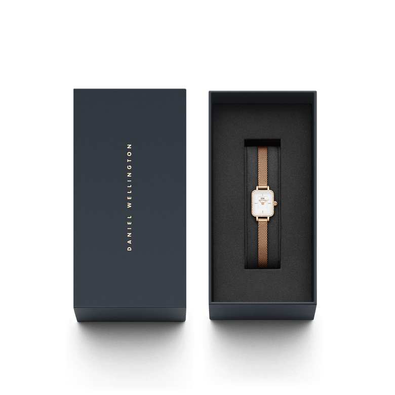 Quadro Mini Lumine Bezel Rose Gold ladies watch with a rectangular white dial and rose gold mesh strap, elegantly presented in a branded Daniel Wellington gift box.