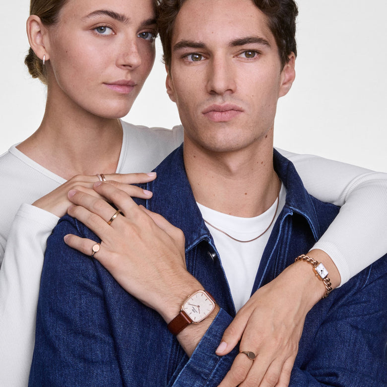 Marlon St Mawes Linen Rose Gold men’s watch with a rectangular rose gold case and brown leather strap, worn in a casual setting with denim and layered jewellery.