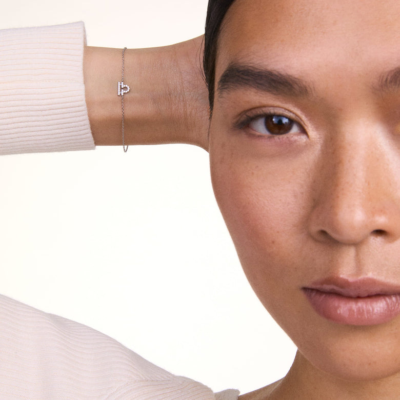 A woman wearing the Crystal Zodiac Chain Bracelet Rose Gold, showcasing the delicate rose gold chain and sparkling zodiac pendant styled for a minimalist, everyday look.