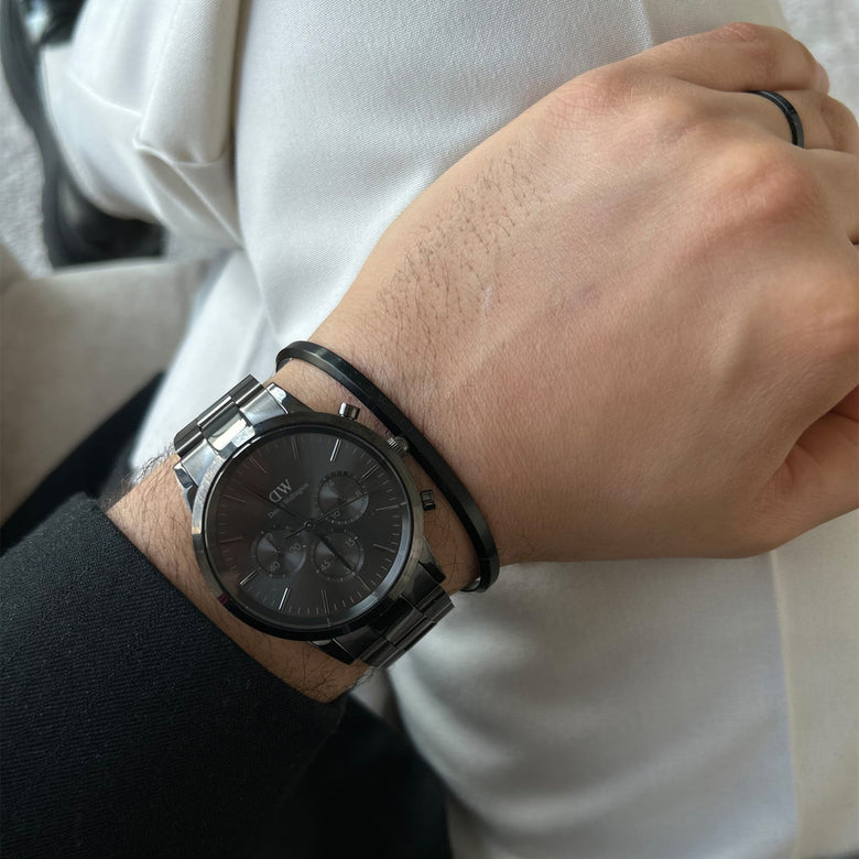 Classic Bracelet in matte black worn alongside a matching black watch, showing its slim cuff design and understated style suitable for everyday and formal wear.