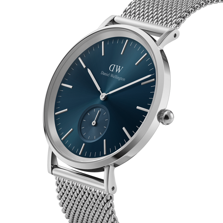 Classic Multi-Eye Sterling Arctic men's watch with a round silver case, deep blue dial, minimalist hour markers, and a stainless steel mesh strap, shown from a side angle to highlight its slim profile and elegant design.