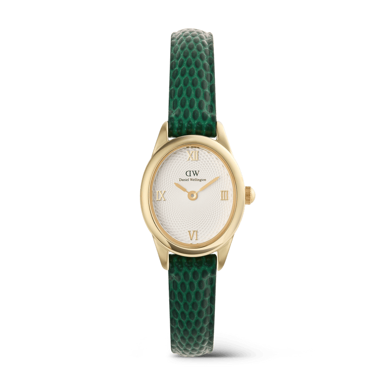 Ladies gold Daniel Wellington Ophelia Mini watch with a petite oval case, white guilloché dial, gold Roman numeral markers, and a green lizard-embossed leather strap.