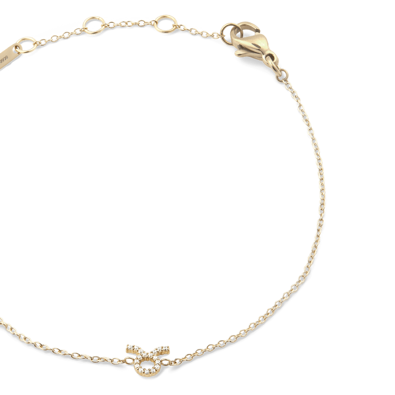 Close-up of the Crystal Zodiac Chain Bracelet Gold with a fine gold chain, adjustable sizing rings, and a crystal-encrusted Taurus zodiac charm at the centre.