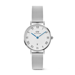 Petite Roman Numerals Date Silver features a 28mm stainless steel case, a textured white dial with Roman numerals, blue hands, a date window at 6 o’clock, and a slim adjustable silver mesh strap.