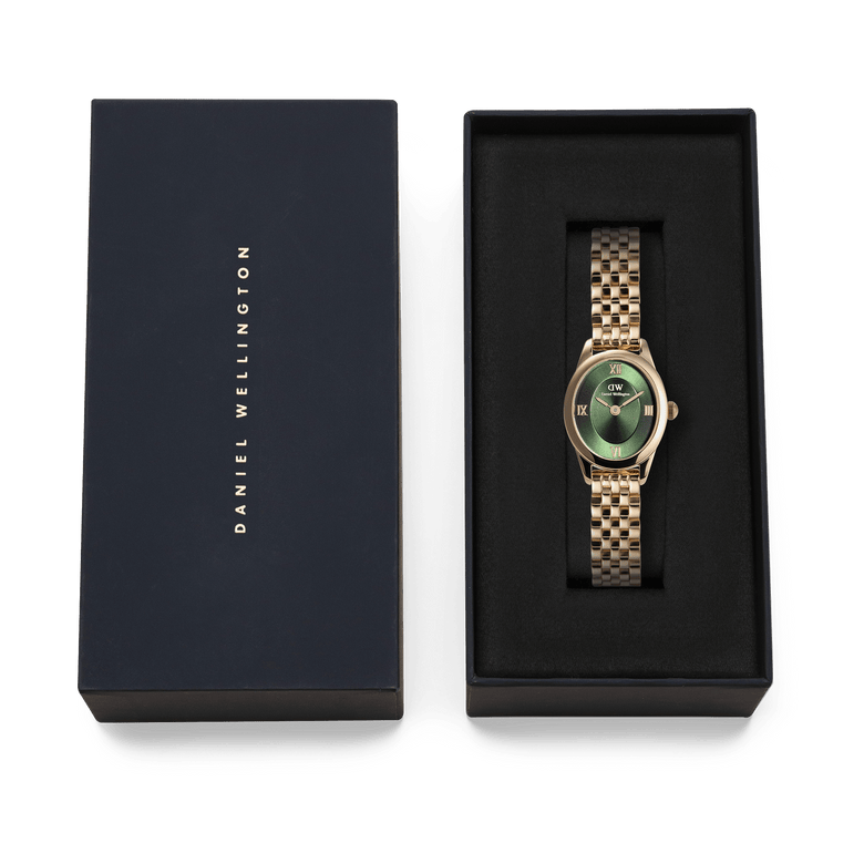 Ophelia Mini Emerald Gold watch with a gold beans link bracelet and emerald green sunray dial, presented in a black Daniel Wellington gift box.