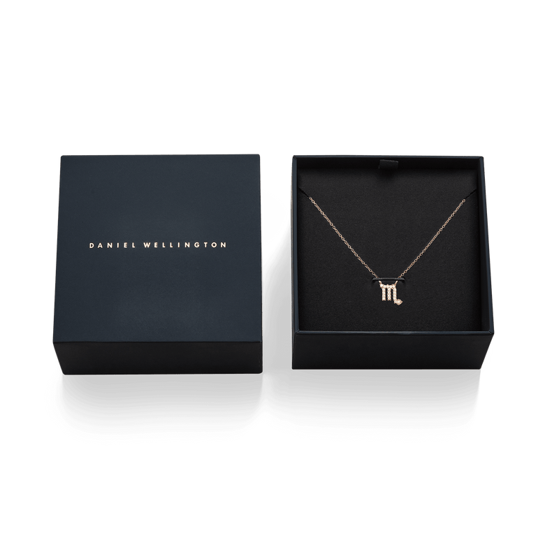 Rose gold Crystal Zodiac Chain Necklace with a crystal-set zodiac pendant, presented in an elegant black Daniel Wellington gift box.