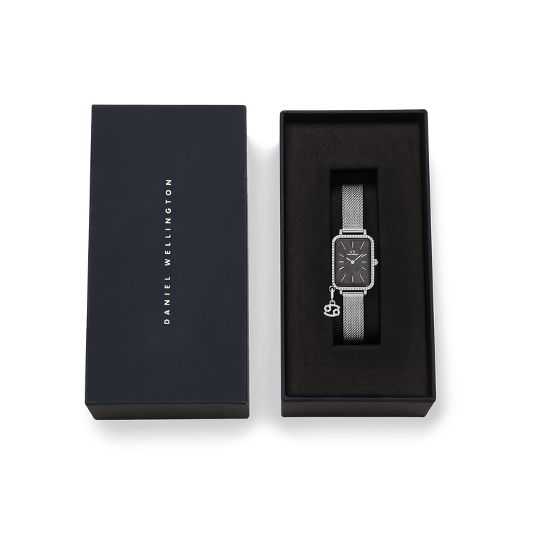 Quadro Crystal Zodiac Sterling watch with a silver mesh strap, black mother of pearl dial, crystal bezel, and zodiac charm, presented in a premium Daniel Wellington gift box.