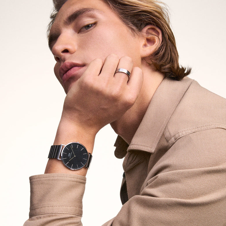 A man wearing the Classic Piano Link Onyx Silver watch, featuring a brushed black dial and geometric silver piano link strap, styled with a beige shirt for a modern, everyday look.