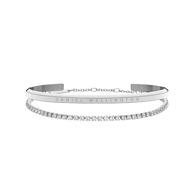 Classic & Tennis Bracelet Silver set featuring a polished minimalist silver cuff with engraved branding and a delicate tennis bracelet adorned with sparkling stones, both designed for elegant layering.