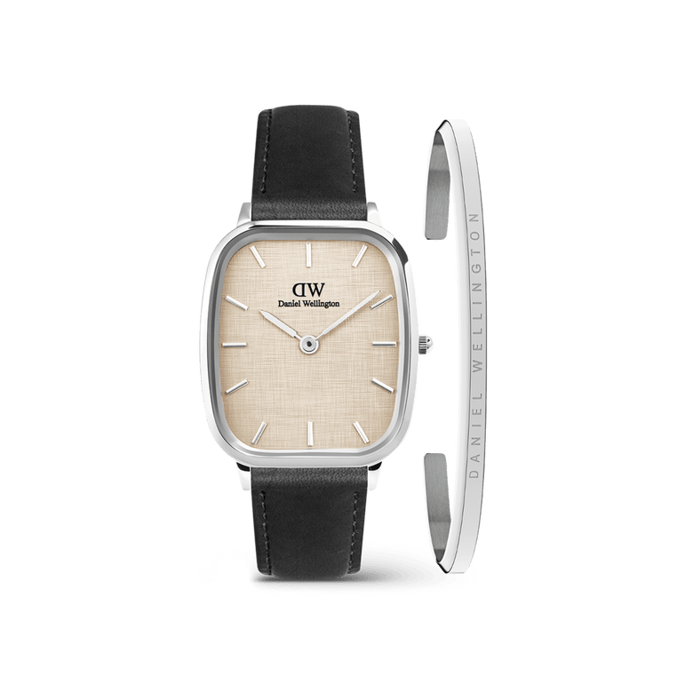 The Marlon Sheffield Linen & Classic Bracelet Silver set features a men’s watch with a cushion-shaped silver case, linen-textured yellow dial, black leather strap, and a slim polished silver bracelet engraved with the Daniel Wellington logo.