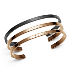 Classic Bracelet Black + 2 Rose Gold set featuring three minimalist stainless steel cuff bracelets, one in matte black and two in polished rose gold, each engraved with Daniel Wellington branding.