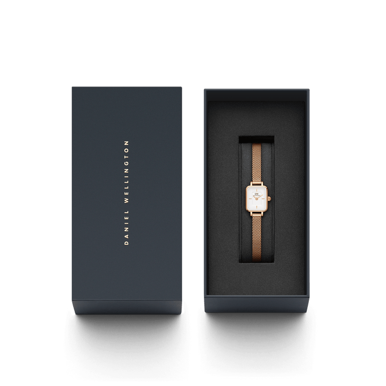 Quadro Mini Melrose watch with a rose gold mesh strap and rectangular white dial, elegantly presented in a branded Daniel Wellington gift box.