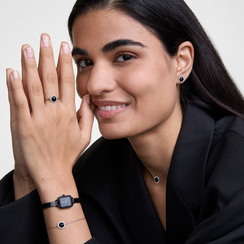 A woman wearing the Audrey Bracelet Black Agathe Silver, styled with matching black agate jewellery including a ring, earrings, and necklace, paired with a black watch and a dark blazer for a sophisticated, coordinated look.