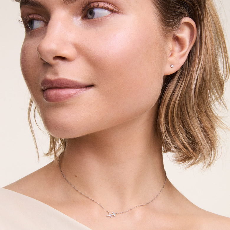 Crystal Stud Silver petite earring with a round cubic zirconia crystal worn in a second piercing, styled with a delicate silver necklace for a minimalist and elegant everyday look.