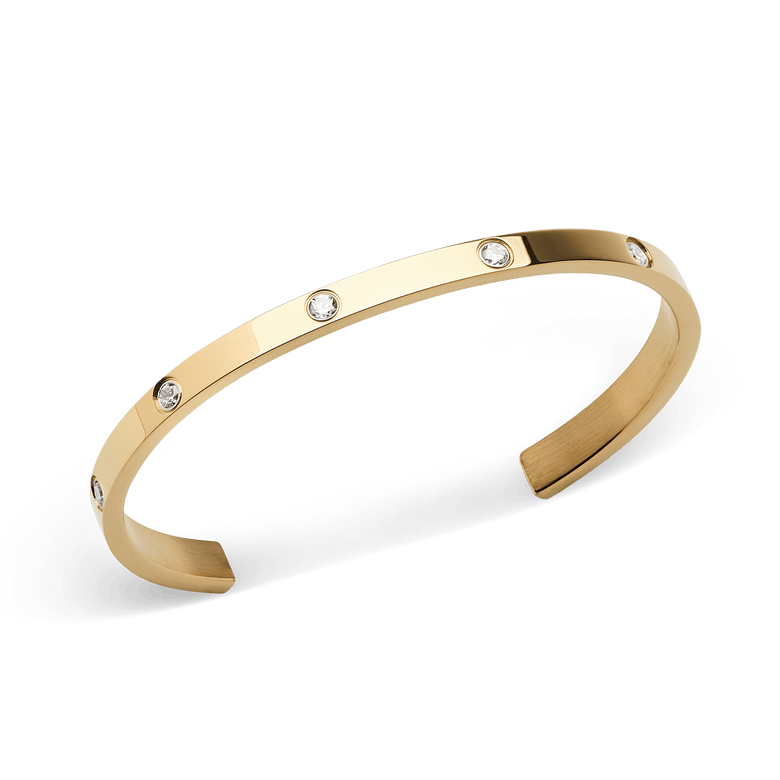 Classic Lumine Bracelet Gold 55mm shown at an angle, highlighting its slim open cuff design, polished gold finish, and eight sparkling cubic zirconia stones set evenly along the band.