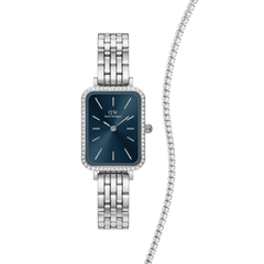 Rectangular Daniel Wellington Quadro Bezel Arctic watch with a polished silver link strap, deep blue dial and crystal-set bezel, paired with a classic silver tennis bracelet featuring a row of sparkling stones.