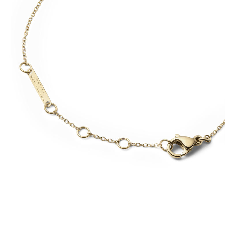 Detail of the Audrey Bracelet Malachite Gold showing the adjustable gold chain with multiple sizing rings, a secure lobster clasp, and a branded tag for a refined finish.
