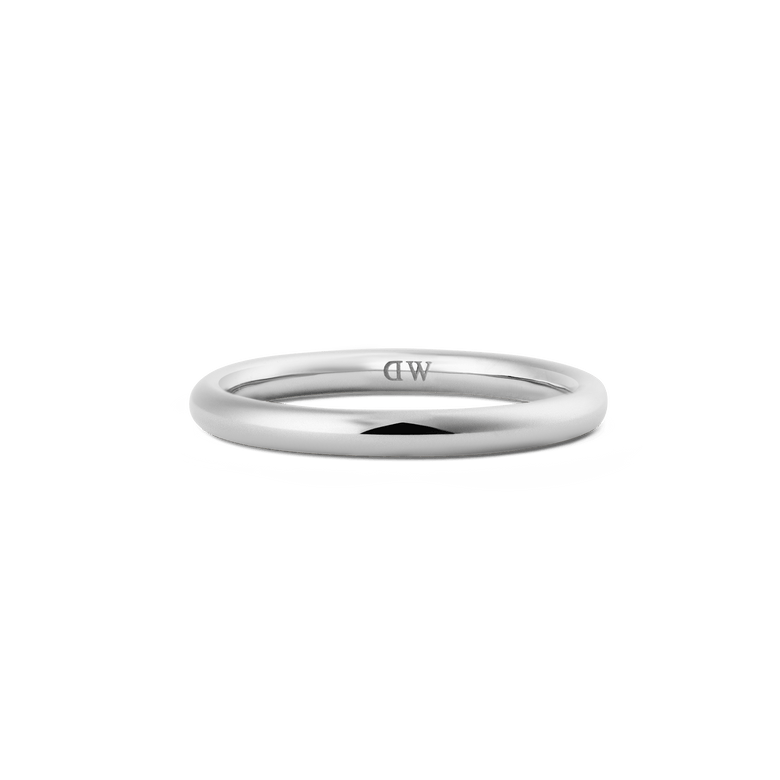 A slim, polished silver ring with a minimalist curved band and discreet inner logo, crafted from stainless steel and designed for versatile, everyday wear.