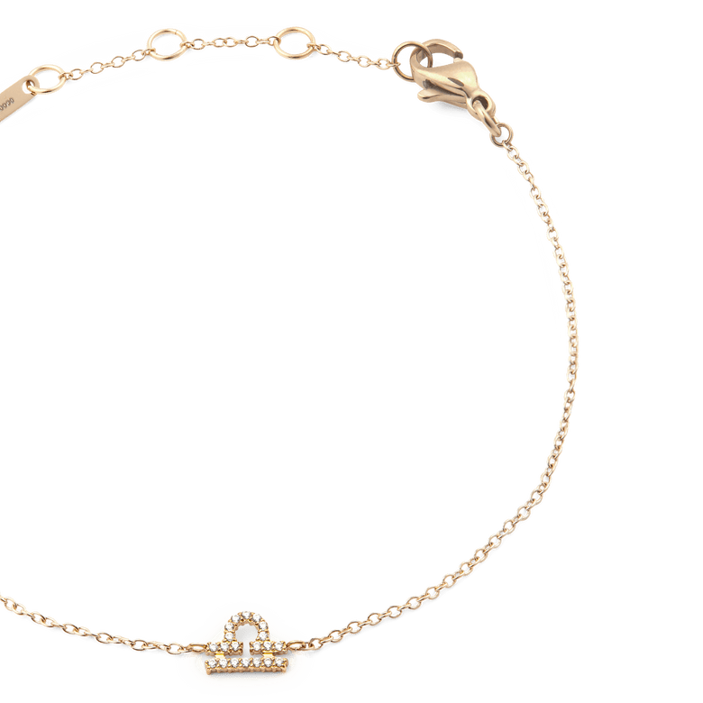 Close-up of the Crystal Zodiac Chain Bracelet Gold, showing the fine gold chain, adjustable sizing rings, and a sparkling Libra zodiac charm set with crystals.