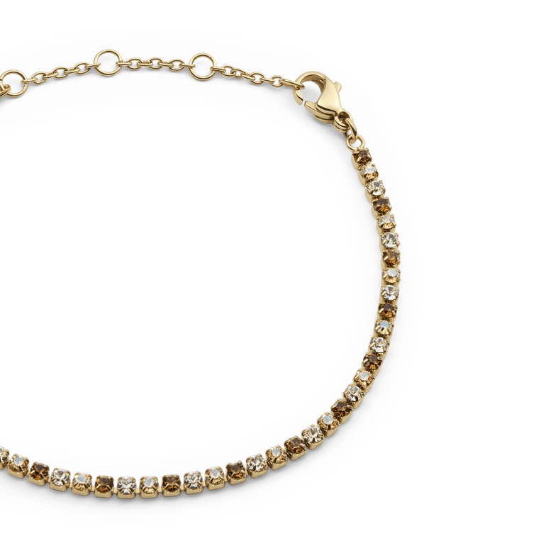 Close-up of the Classic Tennis Bracelet Honey Combo Gold showing individually set honey and clear crystals in a slim gold setting with an adjustable chain and lobster clasp.