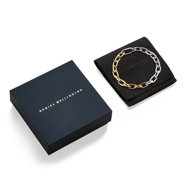 Contrast Link Bracelet Two Tone Gold displayed on a black pouch next to a Daniel Wellington gift box, highlighting its polished gold and silver chain links and elegant packaging.