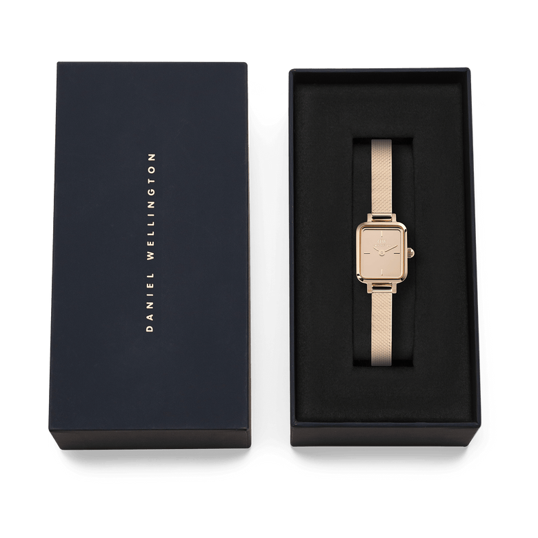 Quadro Mini Reflection Rose Gold ladies watch with a slim rectangular case and rose gold mesh strap, presented in a black Daniel Wellington gift box.