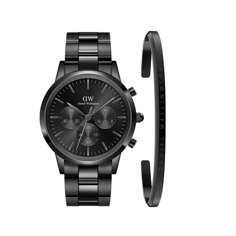 Sleek black chronograph watch with a polished steel link strap, paired with a minimalist black cuff bracelet featuring subtle engraved branding, both crafted from stainless steel for a refined and versatile men's accessory set.
