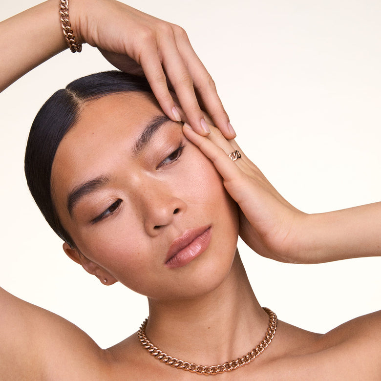 Chunky Chain Bracelet Rose Gold styled on a wrist, paired with a matching rose gold chain necklace, showcasing its bold links and polished finish in a modern, elegant look.