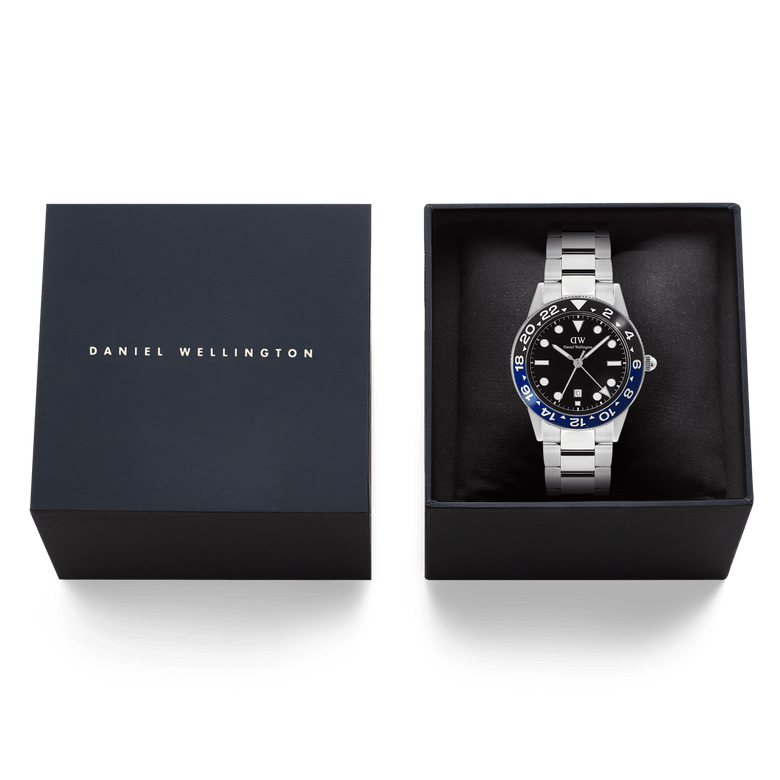 Daniel Wellington Iconic GMT Link Black Blue Ceramic Bezel Silver watch presented in its branded gift box, featuring a black dial, blue and black ceramic bezel, and a silver stainless steel bracelet.