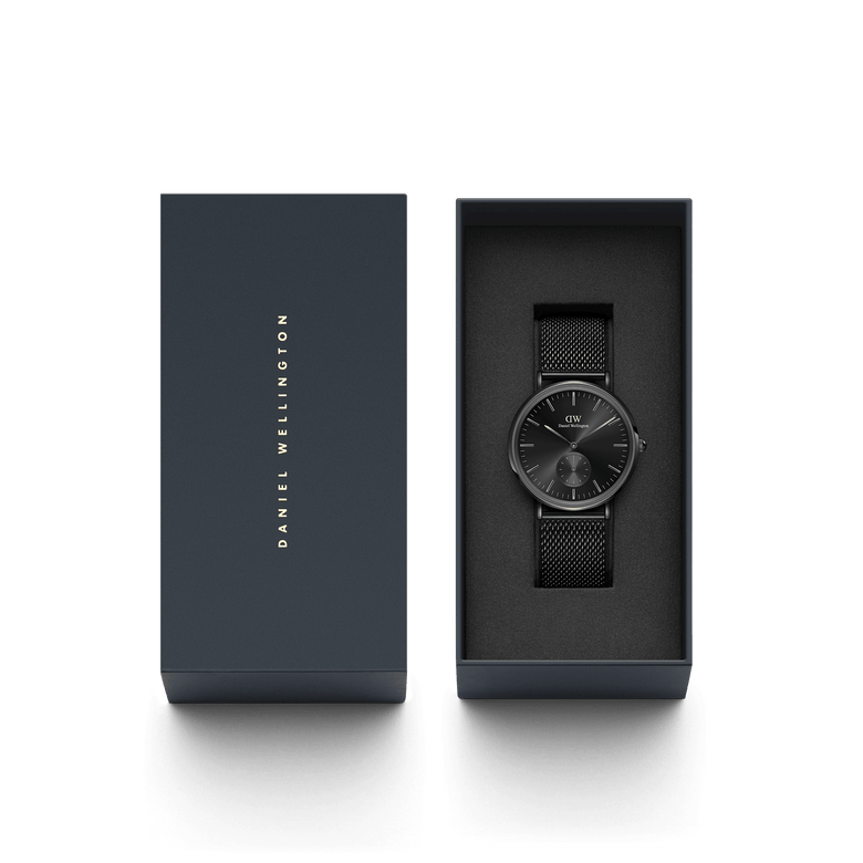 Classic Multi-Eye Ashfield Onyx men's watch with a black mesh strap, presented in a sleek Daniel Wellington gift box, ideal for gifting or special occasions.
